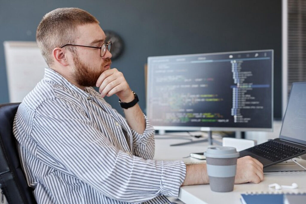 Мужчина смотрит в ноутбук с кодом на Python